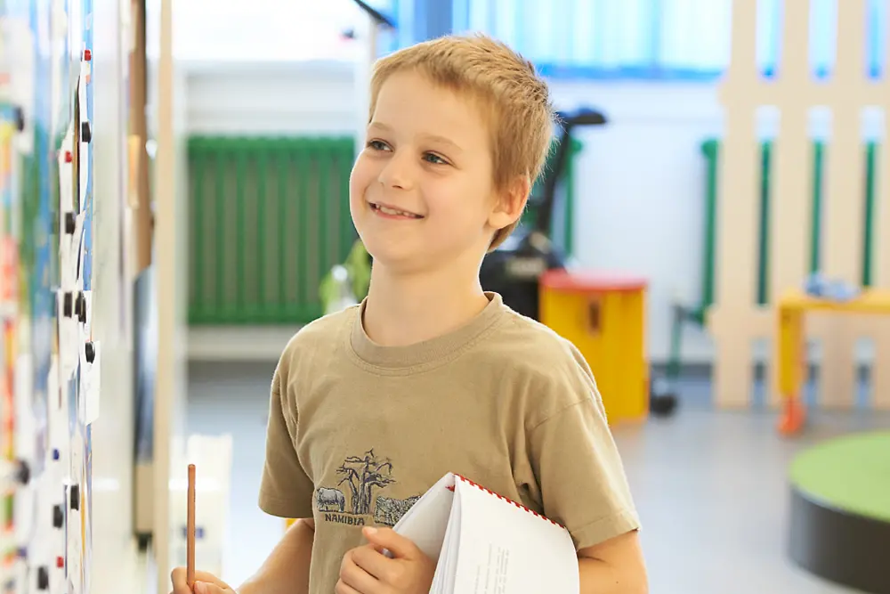 blond boy stands at whiteboard