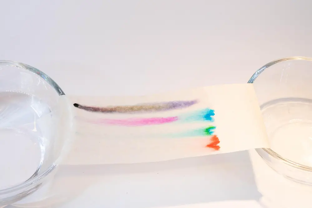 paper stripe showing colorful traces laying across two glass bowls