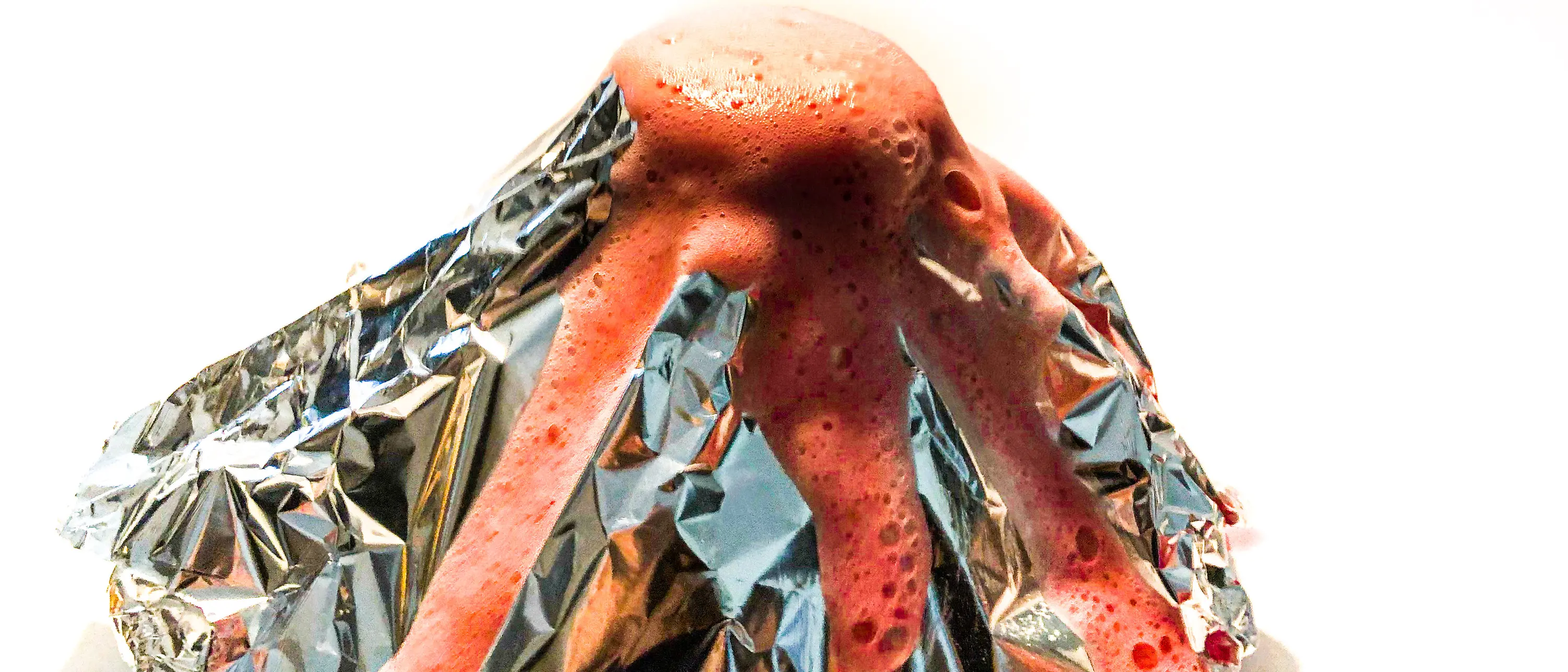 Cone of aluminum foil from the center of which sprouts red foam