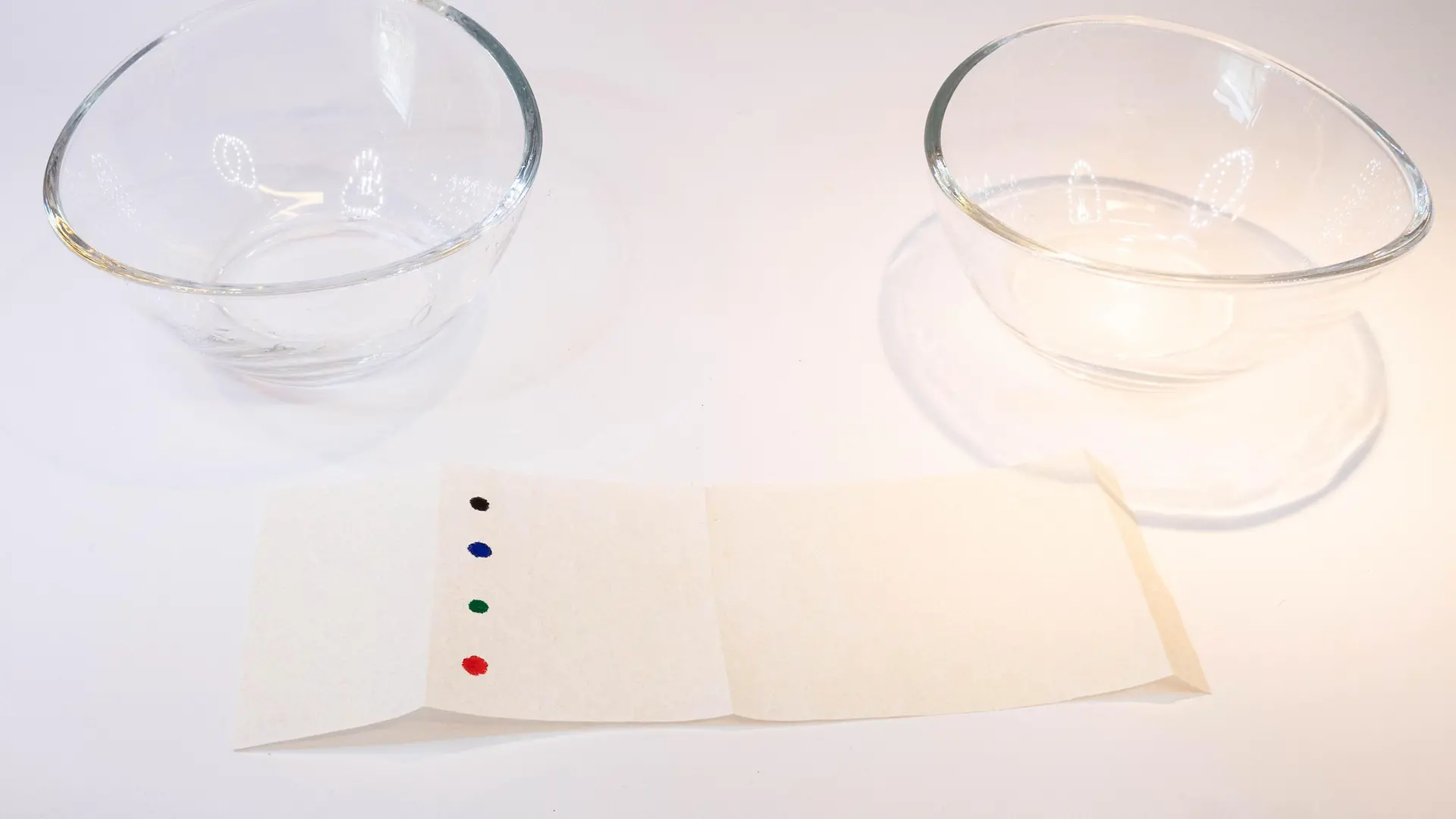 paper stripe with colorfuls dots in front of two glass bowls 