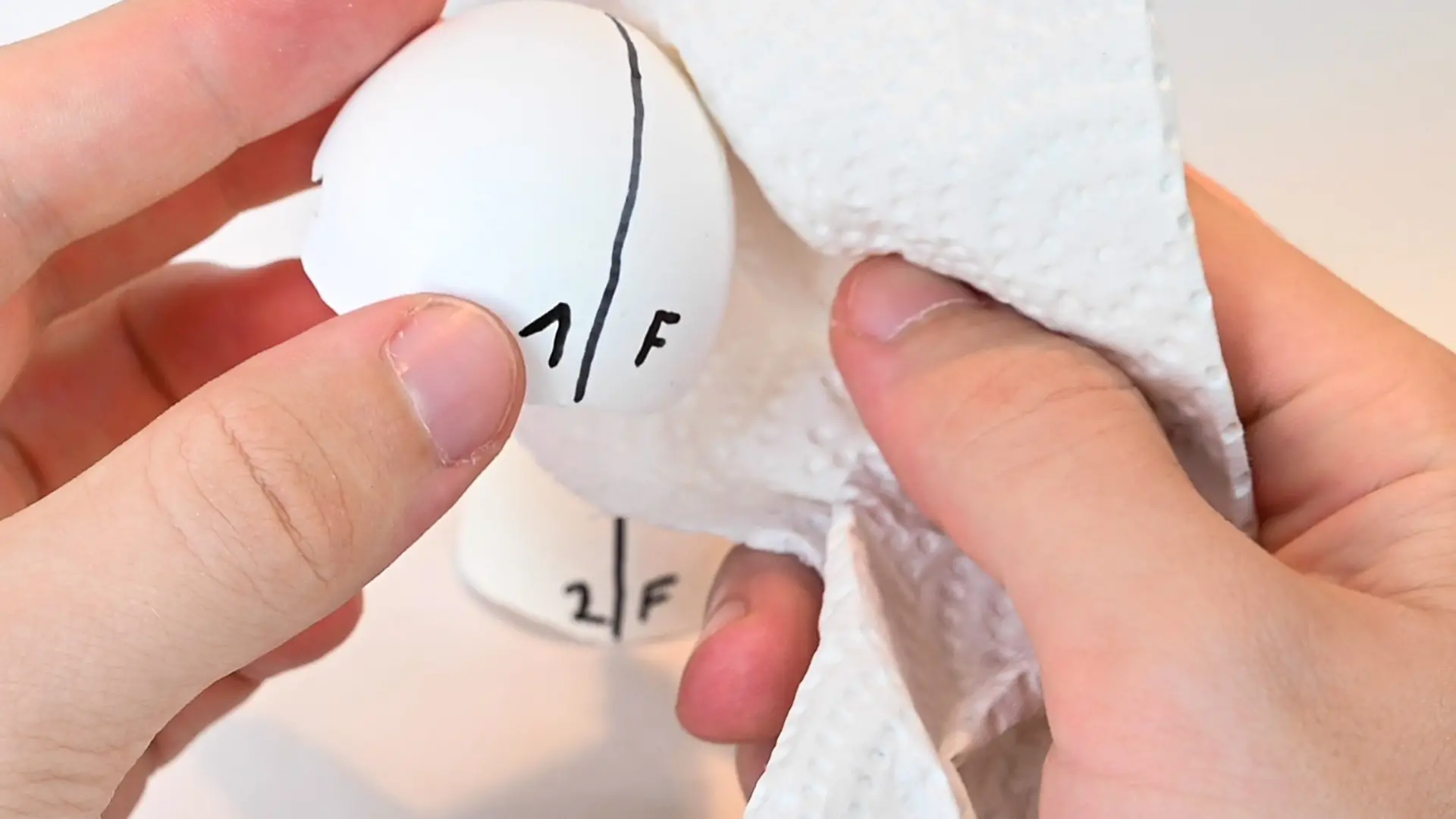 close up of hand with paper towel and eggshell