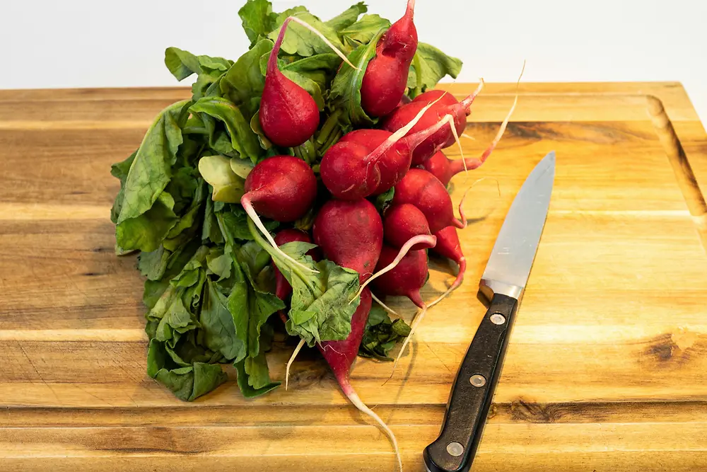 radish on wooden cutting board with knife