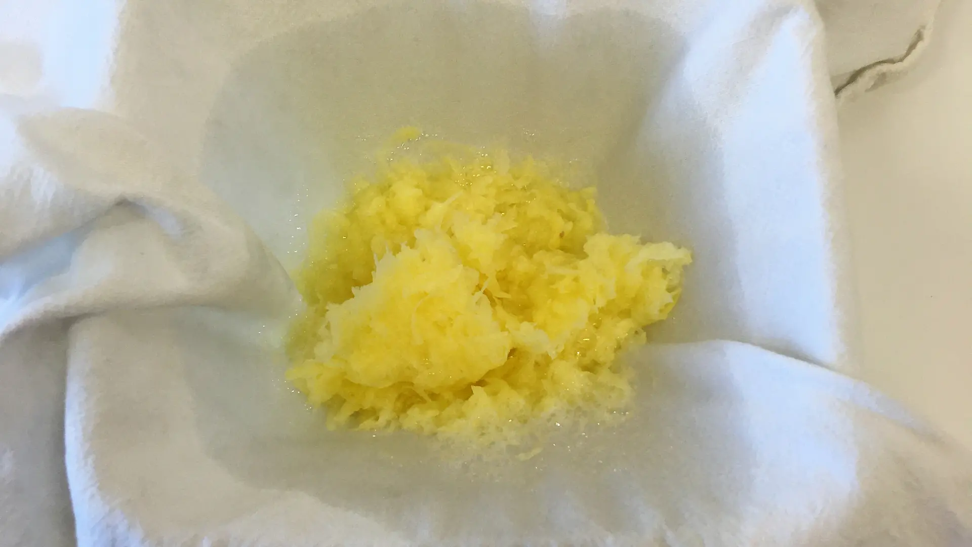 white tea towel covering bowl with grated potato on it