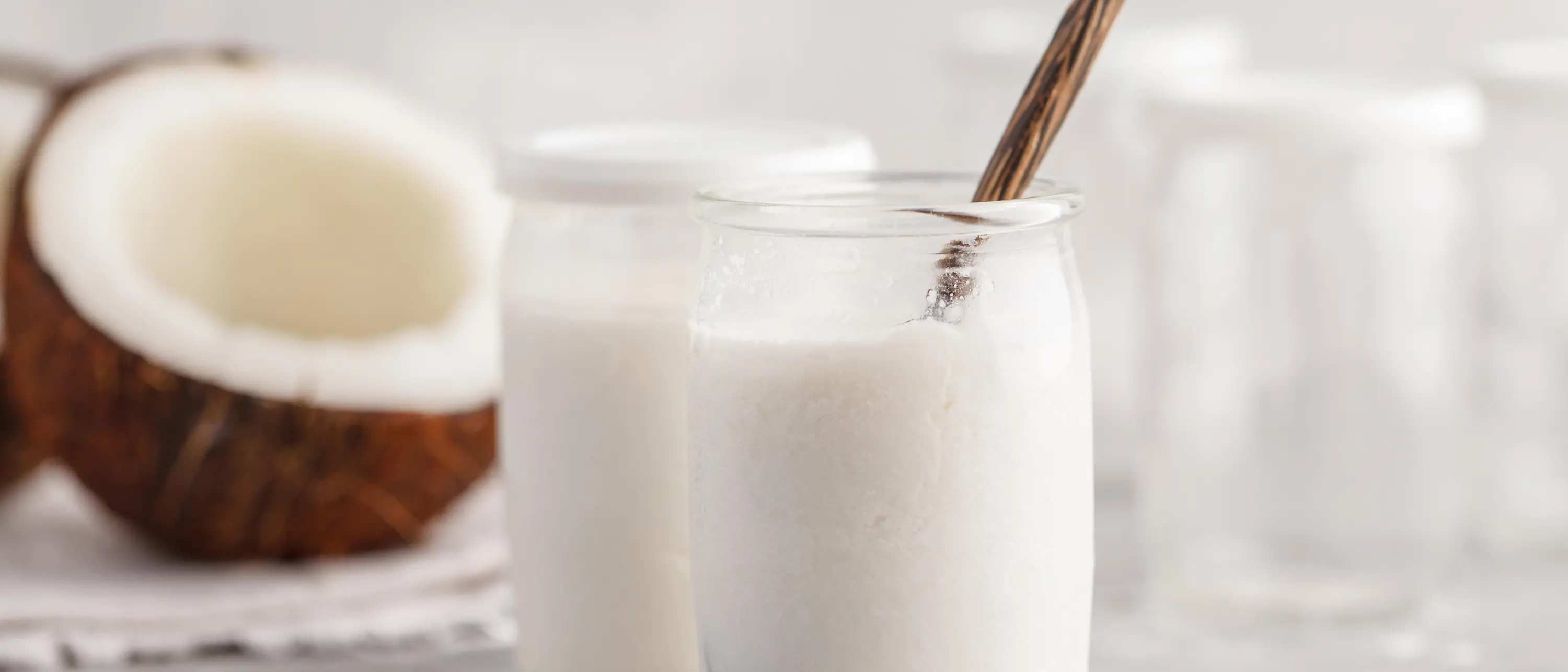 glass jars with yoghurt and coconut half in the background