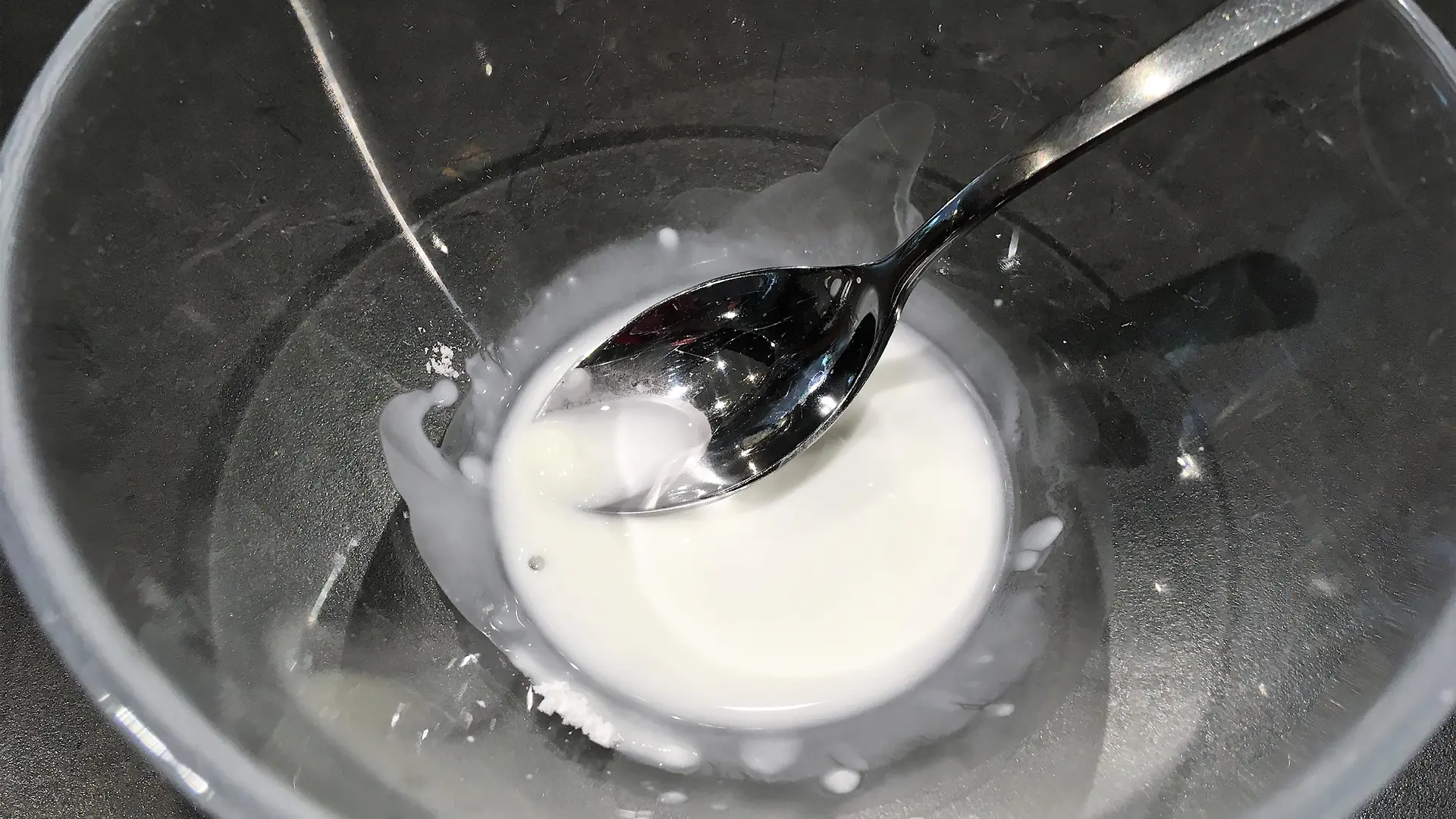 glass bowl with white paste on black background