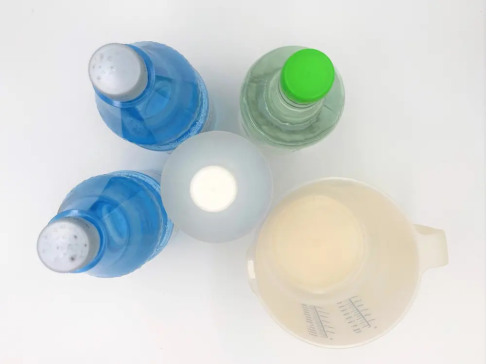 picture from above: four plastic bottles and measuring jug