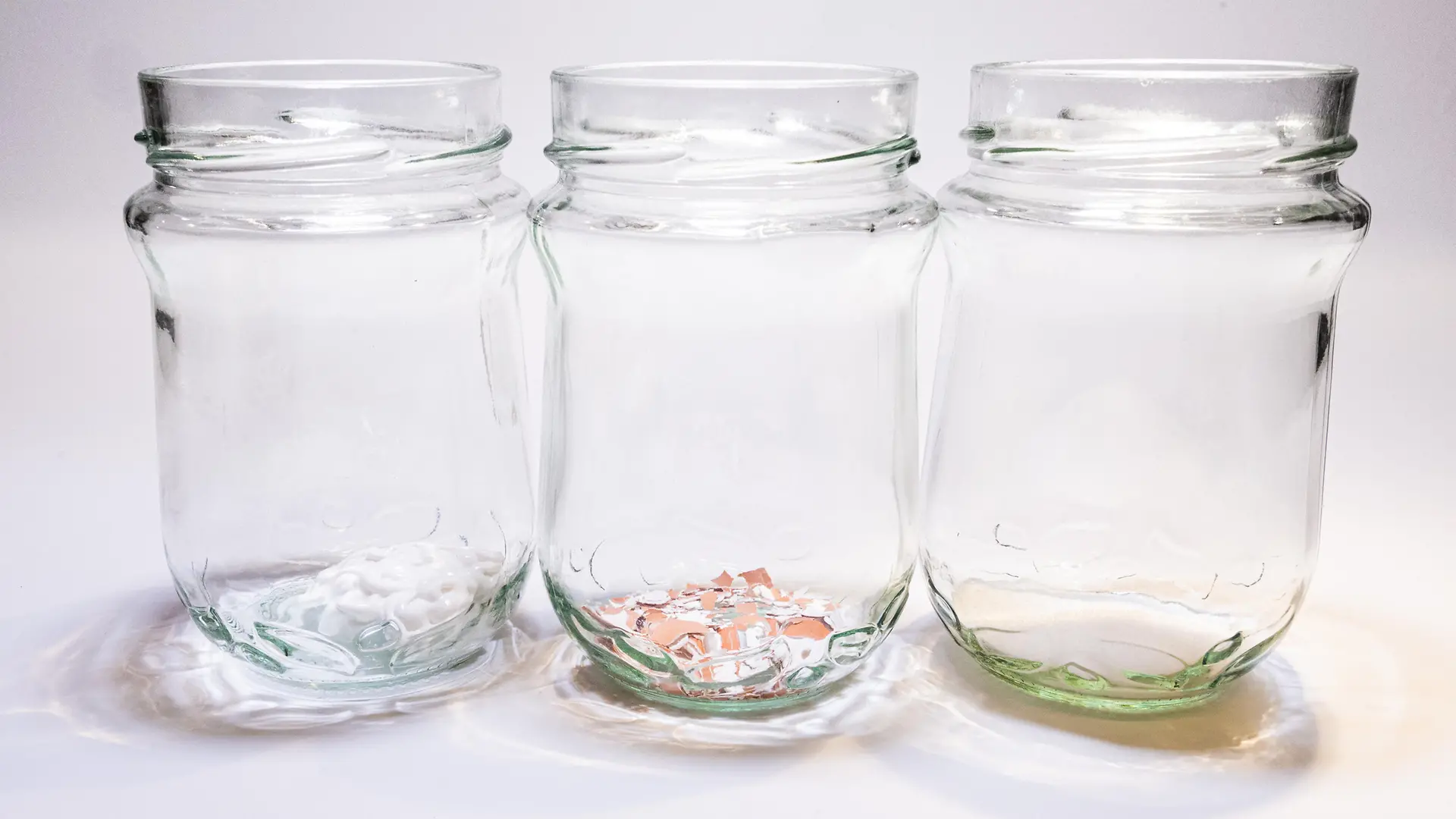 three glass jars with liquid, eggshell powder and toothpaste