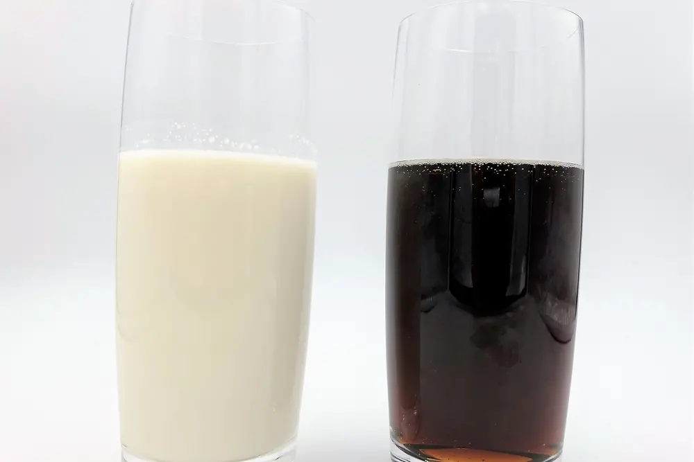 glass with milk besides glass with cola