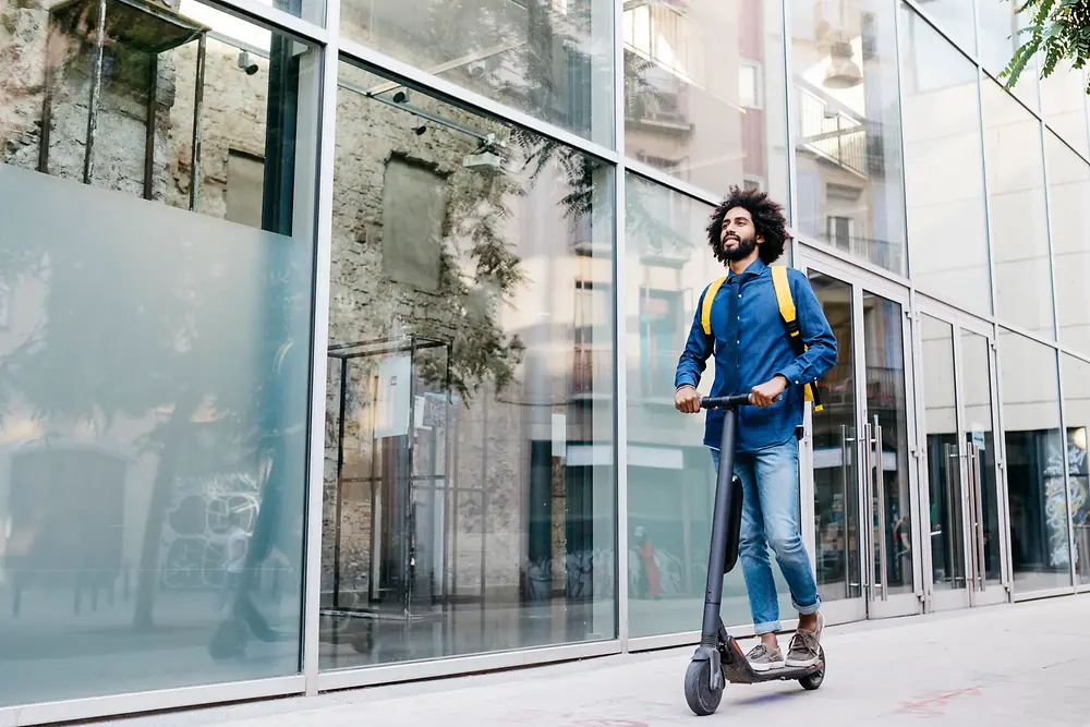 Ein Mann fährt auf einem E-Scooter.