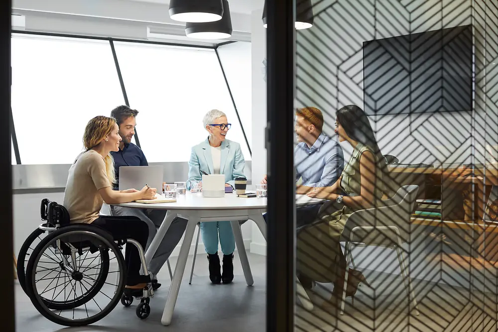 Eine Employee Resource Group sitzt zusammen in einem Meetingraum und tauscht sich aus. 