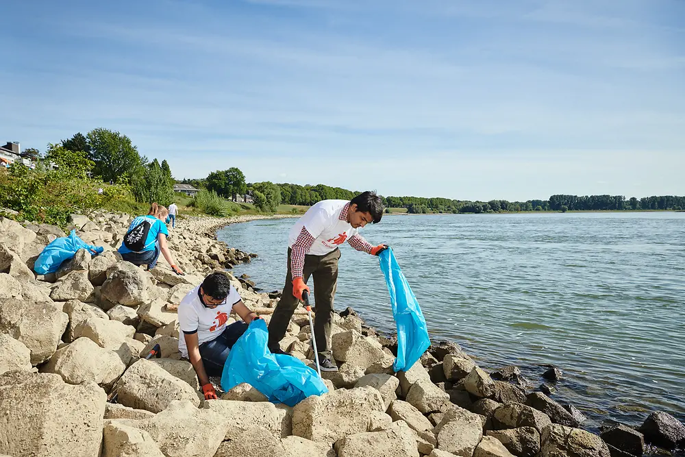  In Düsseldorf arbeiten Henkel-Mitarbeiter als „Trashfighter“ am Rheinufer Hand in Hand.